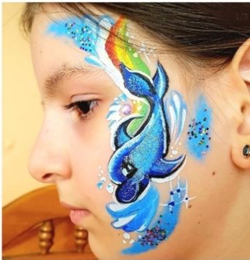 Sirène et arc-en-ciel peints sur le visage d'une enfant